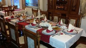 una mesa con platos de comida con sombreros rojos. en Hotel Razgorsek, en Velenje