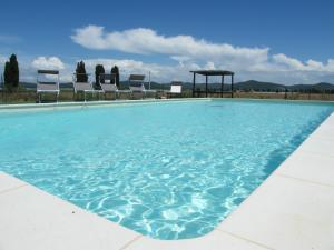 a swimming pool with chairs and a gazebo at Casolare Casa Ricci in Riotorto