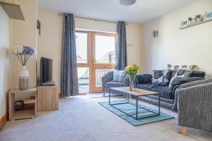 a living room with a couch and a tv at Modern 2 bedroom garden flat in Inverness