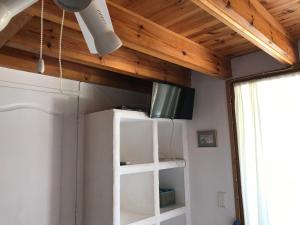 una camera con soffitto in legno e TV su mensola di CHAMBRE HOTES CARPE DIEM a Santa-Maria-Poggio