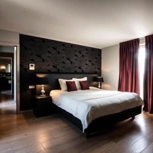 1 dormitorio con 1 cama grande y pared roja en B&B Scheldekant, en Oudenaarde