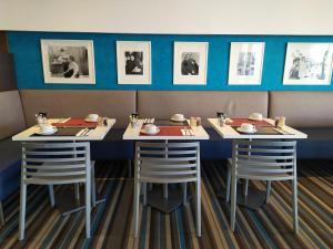 a dining room with two tables and stools at Best Western Premier H&ocirc;tel du Vieux-Port in La Ciotat
