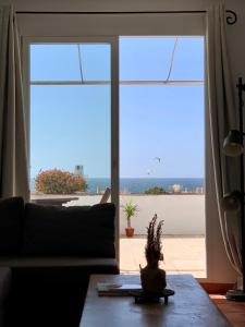 een woonkamer met een bank en uitzicht op de oceaan bij Sunset Los Lances - Tarifa in Tarifa