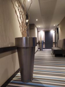 a large black pot on the floor of a lobby at Best Western Premier Hôtel du Vieux-Port in La Ciotat