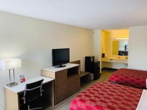 a hotel room with a bed and a flat screen tv at Econo Lodge Crystal Coast in Morehead City