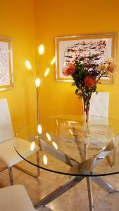 a glass table with a vase of flowers and lights at Penthaus Villa Erika Madeira in Caniço