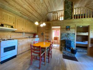 a kitchen with a table and chairs in a cabin at Mo Laksegard in Sand