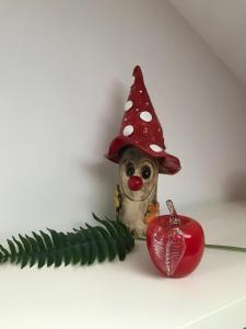 a small dog wearing a hat next to a red apple at Gartenlaube in Thale