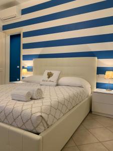 una camera da letto con un letto bianco a righe blu e bianche di Acquamarina a Forte dei Marmi