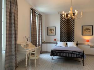 a bedroom with a bed and a table and a desk at Domaine de la Hure in Saint-Symphorien