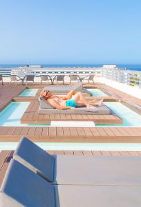 a woman laying on the deck of a cruise ship at Coral Suites & Spa - Adults Only in Playa de las Americas