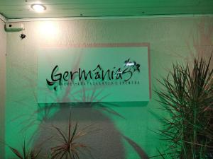a sign on a wall with plants in a room at Germanias Blumen Hotel in Passo Fundo
