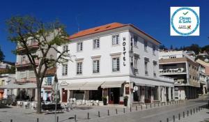 a large white building on the side of a street at Hostel Rossio Alcobaça in Alcobaça