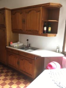 a kitchen with wooden cabinets and a sink at Le Figuier in La Forêt-Auvray