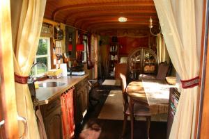 a kitchen with a sink and a table in a train at Vegawagen Psyche, een sprookje in Coevorden in Coevorden