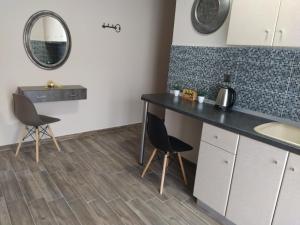a kitchen with a table and two chairs and a mirror at Apartment Julia in Paralia Katerinis