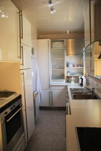 a small kitchen with white cabinets and a sink at Penthaus Villa Erika Madeira in Caniço