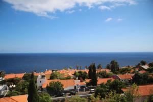 a view of a town with orange roofs and the ocean at Penthaus Villa Erika Madeira in Caniço