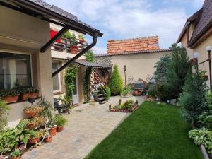 a courtyard of a house with a lawn and plants at Rasnov Retreat in Râşnov