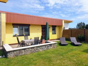 a yellow house with a patio with a table and chairs at Ferienhaus Scheffler in Saal