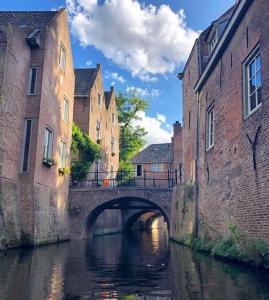 uma ponte sobre um rio entre dois edifícios em The Guest Apartments - Uilenburg em Den Bosch