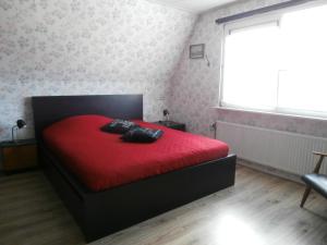 een slaapkamer met een rood bed en een rode deken bij Medemblik Bed and breakfast in Medemblik