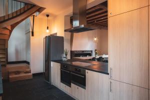 uma cozinha com um frigorífico de aço inoxidável e armários de madeira em Sint-Jacobshoeve 2 em Oudenaarde