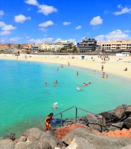 a group of people in the water at a beach at el Bounty de Playa Chica in Puerto del Rosario