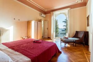 een slaapkamer met een groot rood bed en een raam bij Villa Ondina - Wonderful villa with private beach and big garden in Salò