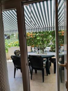 a patio with a table and chairs under awning at Apartman Zvonimir with a beautiful sunset in Silba