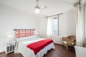 a bedroom with a red and white bed and a window at Uliveto - Apartment in olive grove directly on the lake in Gargnano