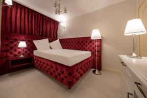 a red bedroom with a bed with two lamps at Hotel Casa Fiori in Bucharest