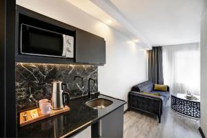 a room with a kitchen with a sink and a microwave at Taksim Seya Suites Hotel in Istanbul