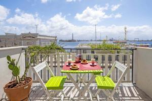 un tavolo e sedie su un balcone con vista sull'acqua di Miti Dello Stretto B&B a Messina