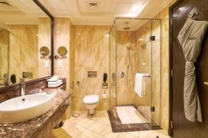 a bathroom with a sink, toilet and shower at Bahi Ajman Palace Hotel in Ajman 