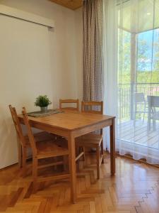 mesa de comedor con sillas y ventana grande en Apartmán Stožec, en Stožec