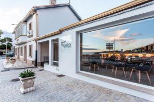 ein Fenster eines Restaurants mit Meerblick in der Unterkunft Mar do Ézaro - Boutique Hotel in O Ézaro