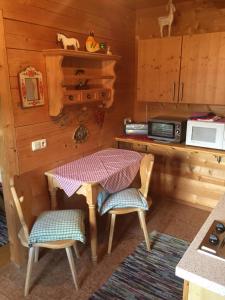 eine kleine Küche mit einem Tisch und 2 Stühlen in der Unterkunft Blockhaus-Traum Huber in Garmisch-Partenkirchen