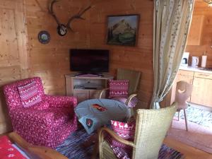 un soggiorno con sedie e TV in una cabina di Blockhaus-Traum Huber a Garmisch-Partenkirchen