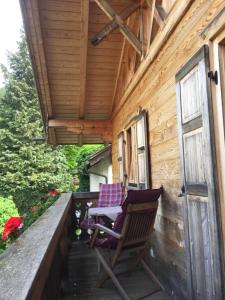 two chairs on the porch of a wooden cabin at Blockhaus-Traum Huber in Garmisch-Partenkirchen