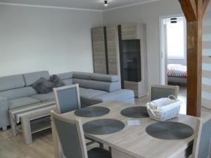 a living room with a table and a couch at Apartament w Węgorzewie in Węgorzewo +8 photos