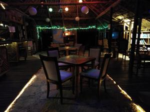 a restaurant with tables and chairs at night at Casa Bambután in Palenque
