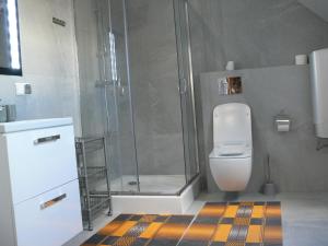a bathroom with a shower and a white toilet at Apartament w Węgorzewie in Węgorzewo