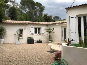 uma casa branca com vasos de plantas num quintal em Villa OHA close Cannes,Nice, Valbonne , Opio em Roquefort Les Pins