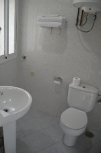 a white bathroom with a toilet and a sink at Estudio Puerta del Sol Esparteros in Madrid