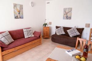 a living room with two couches and a table at Residence Les Cimes in Font-Romeu