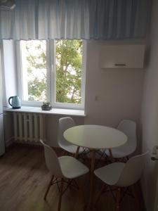 mesa y sillas en una habitación con ventana en Helski en Hel