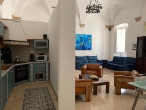 a kitchen and a living room with blue furniture at Chiama Ride the Beauty Assisi in Assisi