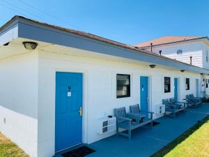 a building with blue doors and benches on it at Sand Dollar Motel in Atlantic Beach