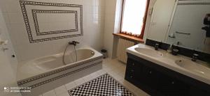 uma casa de banho branca com uma banheira e um lavatório em Arco di San Francesco em Atri